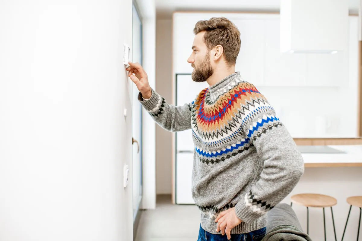 Elektrische vloerverwarming instellen via bedieningspaneel aan de wand in een woning.